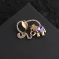 Detail of golden elephant brooch with sparkling rhinestones and a colorful gemstone - Gold