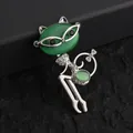 Macro shot of silver cat brooch featuring green opal stone and sparkling rhinestones - Green Cat