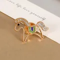Elegant gold horse brooch with rhinestones and colorful crystal saddle detail - Steed Style / Gold