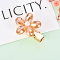 Detailed close-up of amber crystal flower hair clip with white faux pearl and gold plating - Yellow Crystal