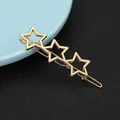 Close-up of golden alloy hair clip featuring three hollow star-shaped geometric elements - Horizontal Triple Star Style