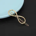 Detail of a golden infinity symbol hair clip with a sleek metallic finish and polished surface - Infinity Symbol Style