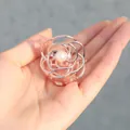 Minimalistische Haarklammer in Roségold mit Perle und Blumenform in der Hand - Roségold