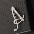 Primer plano de broche letra A con cristales sobre joyero negro con textura acolchada - Letra A / Plata A