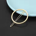 Close-up of minimalist golden alloy circular hair clip with smooth polished metal finish - Minimalist Circle Set Style