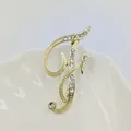 Elegante broche dorado con letra F decorado con pedrería brillante y acabado metálico - Letra F / Dorado