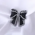 Elegant black bow brooch accessory with white imitation pearls on white fabric - Pearl Edge Bowknot / Black