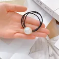 Detailaufnahme von hochelastischem Haargummi mit irisierender Perle und Goldrand-Dekor - Runder Perlenanhänger Dreistrang-Haarseil