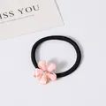 Détail d'un élastique à cheveux avec une fleur délicate en résine rose et strass central - Rose