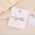 Primo piano di fermacapelli dorato a forma di X con strass brillanti su cartoncino - Stile Strass Incrociato a X (Oro 1)