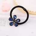 Detalle macro de goma para el pelo con dije de flor de cristal azul y diseño elegante - Flor De Cristal Azul