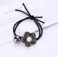 Detalle de coletero negro con dije de flor de cristal gris y cuenta metálica brillante - Flor Negro