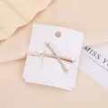Vista macro dettagliata dei fermagli per capelli con perle e strass su base dorata - Stile con perle artificiali pavé incrociate (Oro 7)