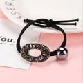 Detalle de goma de pelo negra con anillo de cristal gris oscuro y colgante de bola - Estuche Ovalado Negro