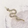 Detalle de una pinza para el cabello de serpiente dorada con cristales blancos y ojos negros - Clip de Serpiente Dorado con Diamantes de Imitación