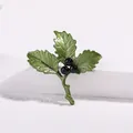 Detail of green leaf enamel brooch with black pearls on a white stone base - Three-Leaf Style