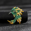 Vista macro de broche de fénix en esmalte degradado con cristales sobre fondo cuero - Multicolor Fénix