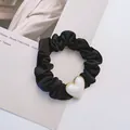 Elegant black satin scrunchie featuring a luminous white heart pearl pendant for women - Heart