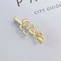 Detail of gold metal flower hair clip with sparkling rhinestones on a white background - Gold