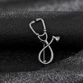 Vista macro de un broche de estetoscopio plateado con texturas metálicas sobre tela negra - Estetoscopio Negro