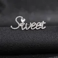 Close-up of a silver-toned 'Sweet' brooch with heart-shaped stone and crystal pavé details - Silver Sweet Style
