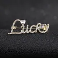 Macro detail of Lucky brooch in gold alloy with white rhinestones on black stand - Golden Lucky Style