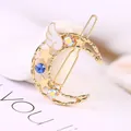 Goldene Mond-Haarklammer mit Sternen, Engelsflügeln und bunten Strasssteinen - Mond Blau Strass