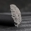 Detalle macro de un broche de pluma plateada con pedrería brillante e incrustaciones - Pluma de Rhinestone Plateada