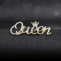 Macro detail of a golden Queen brooch with sparkling crystals and a crown detail - Golden Queen Style