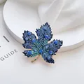 Elegant maple leaf brooch with blue gradient crystals and gold plated metal finish - Blue