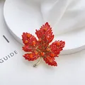 Elegant maple leaf brooch with vibrant red and orange rhinestones set in gold metal - Red