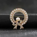 Detalle de broche de corona dorada con strass brillantes y una gran perla central - Lazo con Cristales