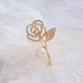 Elegante spilla a rosa dorata con cristalli e grande perla su carta strutturata bianca - Fiore di Rosa d'Oro