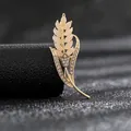 Detalle del broche de espiga dorada con piedras de marfil y brillantes diamantes - Espiga de Trigo Ojo de Gato Dorado