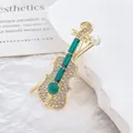Détails de la broche violon avec pierres émeraude, strass blancs et perle élégante - Vert