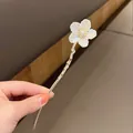 Detalle de horquilla de lirio de los valles con perlas y varilla dorada ondulada - Flor Aspecto Concha