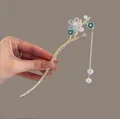 Detalle de una horquilla de pelo dorada con flores azules y borlas de perlas elegantes - Flor Azul con Borla