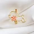 Broche de perro dorado calado con flor rosa sobre elegante tela de satén blanco - Cachorro Dorado