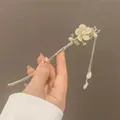 Gros plan détaillé d'une épingle à cheveux rétro avec muguet et glands en soie - Magnolia avec Gland