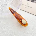 Detalle de horquilla de carey ámbar con incrustación metálica dorada decorativa - Gota de Agua Café