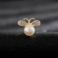 Macro de un broche de abeja con perla blanca y alas brillantes de pedrería dorada - Abeja Pequeña
