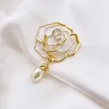 Close-up of camellia brooch with white enamel petals and hanging teardrop pearl - White