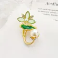 Detailed close-up of a lotus brooch featuring green enamel leaves and shimmering pearls - Green Lotus Style / Green