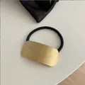 Detail van de gouden geborstelde metalen plaat op een zwart elastisch haarelastiek - Vierkant / Goud