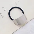 Detailopname van zilveren geborstelde metalen gesp op elastische haarwokkels - Boog / Zilver