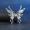 Silberne Schmetterlingsbrosche aus flüssigem Metall mit Tropfeneffekt auf schwarzem Grund - Silberner Schmetterling