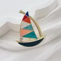 Macro detail of enamel sailboat brooch with colorful sails and sparkling rhinestone - Colorful Sailboat