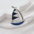 Detail of enamel sailboat brooch with black and white sails and sparkling crystal accent - Blue-Grey Sailboat