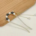 Eleganter U-förmiger Haarnadel mit schwarzen Kamelien, weißen Perlen und Goldquasten - Schwarz