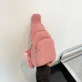Nahaufnahme der rosa Cord-Brusttasche mit weicher Textur und zwei Reißverschlussfächern - Rosa